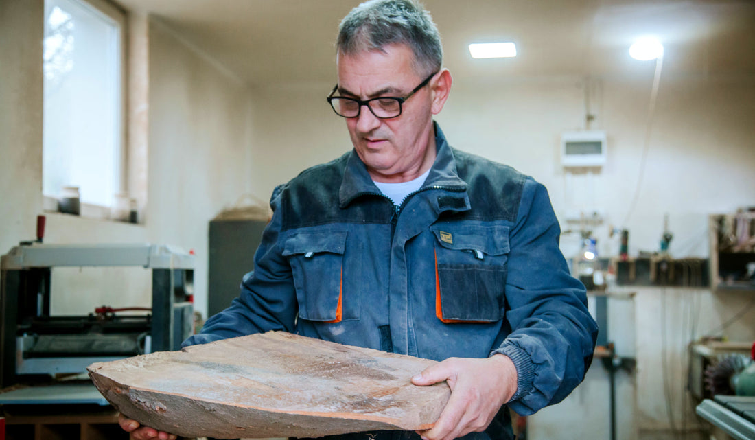 The owner of the company holding a piece of raw wood 
